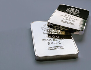 Two minted silver bars weighing 250 grams each on a gray background.