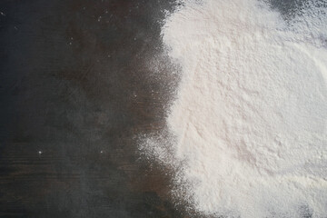 Flour on the wooden kitchen table background top view.