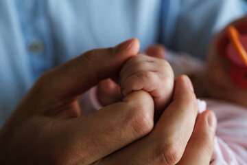 Father's male hand holding a child's small hand