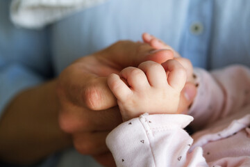 Father's male hand holding a child's small hand