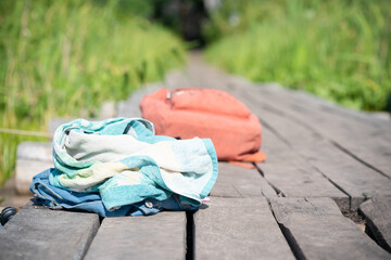 Clothes, towel and backpack on the old pier background.