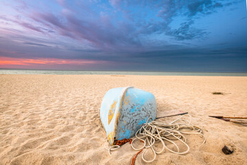 Łódź rybacka na plaży o zachodzie słońca - obrazy, fototapety, plakaty