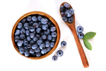 Blueberries in a wooden bowl with a spoon