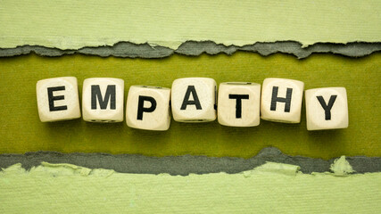 empathy word abstract in wood cubes against handmade rag paper, ability to understand and share the...