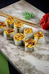 Sushi. A serving of fresh Japanese rolls on a marble board with soy sauce, wasabi and pickled ginger.