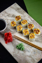 Sushi. A serving of fresh Japanese rolls on a marble board with soy sauce, wasabi and pickled ginger.