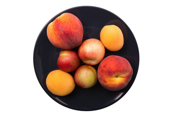 Peach and apricot on a black plate isolated on a white background