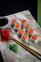 Sushi. A serving of fresh Japanese rolls on a marble board with soy sauce, wasabi and pickled ginger.