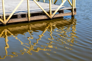 Fototapeta premium Wooden flooring with railings is reflected in the water