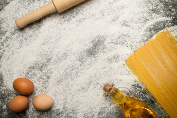 Spilled flour, rolling pin, eggs, bottle with butter. Ideas as a background