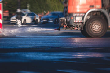 Cleaning flusher sweeper machines washes the city streets road with water spray, group of municipal...