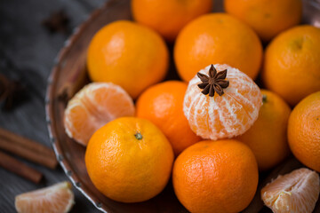 Tangerines in a copper dish on the old wooden background, table. Retro vintage style, selective focus.
