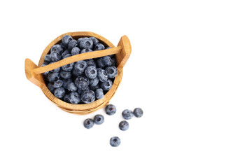 Blueberries in a wooden basket on a white background, top view.
