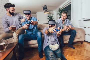 Happy friends playing video games with virtual reality glasses - Young people having fun with new...