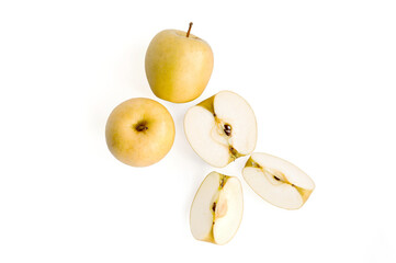 three yellow apples on a white background: two whole, one cut