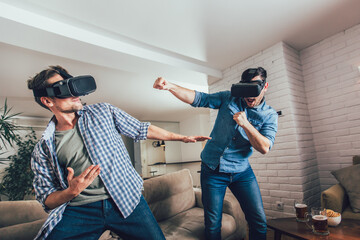 Happy friends playing video games with virtual reality glasses - Young people having fun with new...