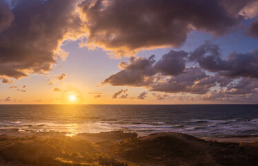 Naklejka na ściany i meble Sunset clouds on sea beach of romantic vacation