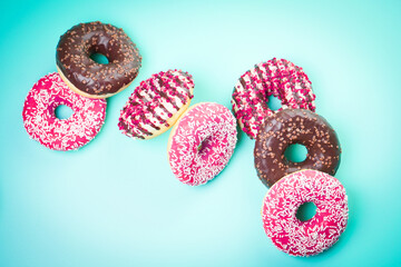 Multicolored sweet donuts on blue background.
