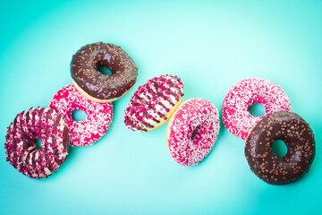 Multicolored sweet donuts on blue background.