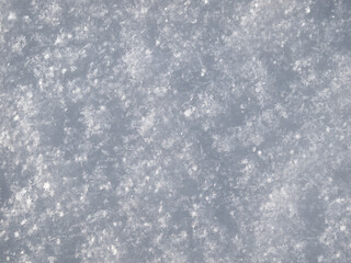 Snow background, white newly-fallen snow surface texture closeup
