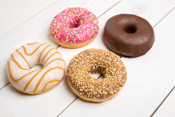 Sweet donuts, cakes on a white wooden table