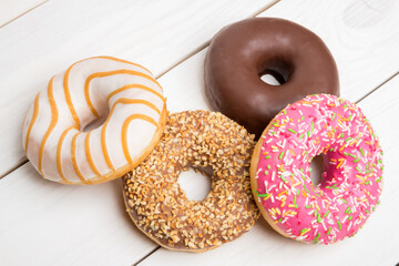 Sweet donuts, cakes on a white wooden table