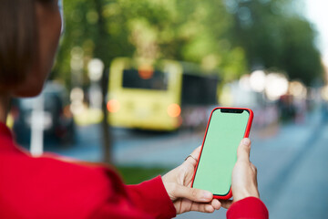 female arms holding chroma key smartphone at modern street