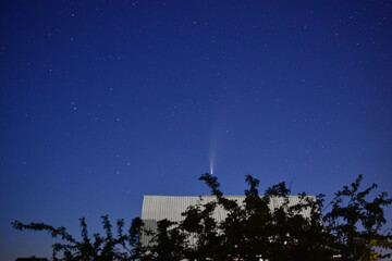 Starry sky in summer in the village and comet neowise