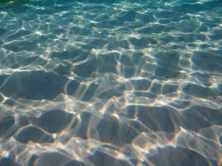Sandy ocean floor with sunlight patches underwater background