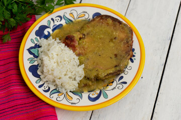 Mexican smoked pork chops with green sauce and rice on white  background