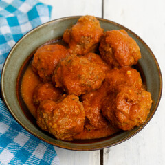 Meatballs in red sauce on white background