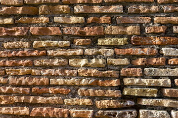 Old brickwork. Antique masonry. Weathered wall, a binding solution is visible.