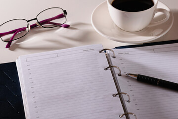 notebook pen and glasses lie on the table