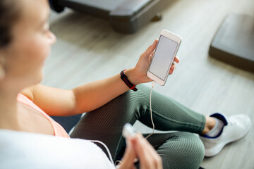 Close-up of athletic woman using mobile phone in a gym.