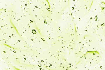 Green aloe gel background. Beauty serum, cosmetic gel with bubbles texture. Clear colored skincare product closeup