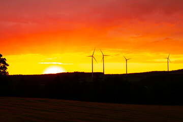 Orange Sky Sunset with wind turbines in the background