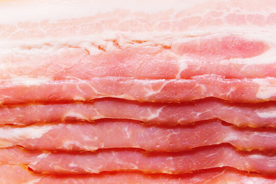 Bacon slices background. Cold fresh bacon strips closeup