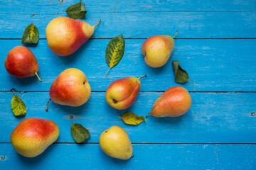 Ripe pears on a blue wooden background, a table of boards, top view.