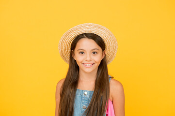 Carefree and happy. happy childhood. joyful summer holiday and vacation. kid seasonal fashion. carefree beauty on yellow background. smiling kid in straw hat. little child ready for beach activity