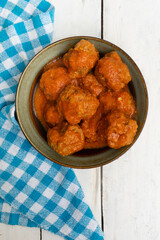 Meatballs in red sauce on white background