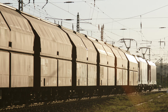 g&uuml;terzug mit zwei elektrischen lokomotiven im flachen gegenlicht