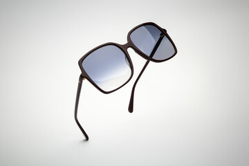Sunglasses of flying on white and grey background. Sun glasses summer woman accessories as design...