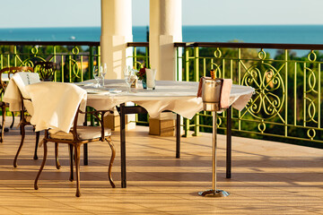 outdoor summer terrace, with cast iron.stylish furniture, in a cafe at sunset
