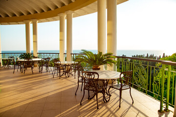 outdoor summer terrace, with cast iron.stylish furniture, in a cafe at sunset