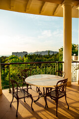 outdoor summer terrace, with cast iron.stylish furniture, in a cafe at sunset