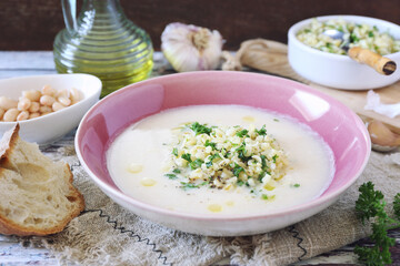 White bean cream soup with fried pearl barley and parsley, bread and olive oil