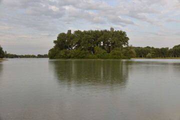 beautiful lake at sunset, the rays of the sun paint the water and small waves in gold, red, orange