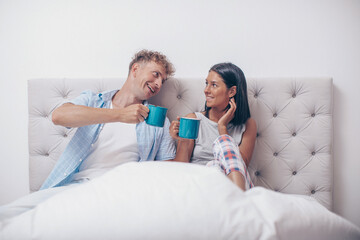 Young Couple Drink Coffee Sitting In Bed, Happy Smile Young Man And Woman. Couple in love. Good morning. Happy day. Sensual. 