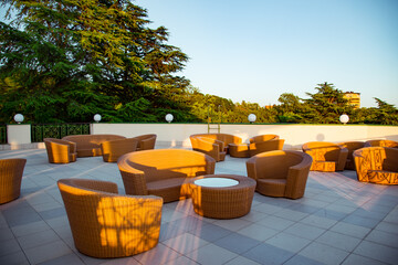 outdoor summer terrace, with stylish rattan furniture, in a cafe at sunset