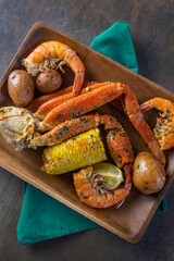 Image of Platter of southern garlic crabs seafood boil with Alaskan crab legs, small new red potatoes, corn on the cob, and shrimp printed on Printed Glass Basin Splashbacks